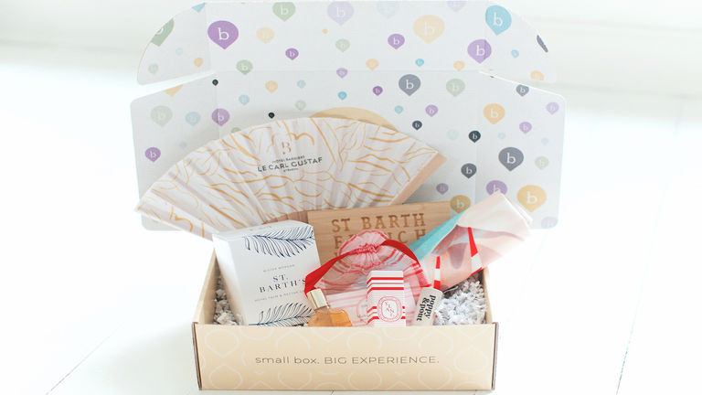 A pre-trip package from BookItBox Travel includes items themed to a client’s destination.