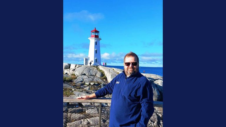 Henry Dennis stands in front of Peggy’s Cove Lighthouse in Nova Scotia, Canada.